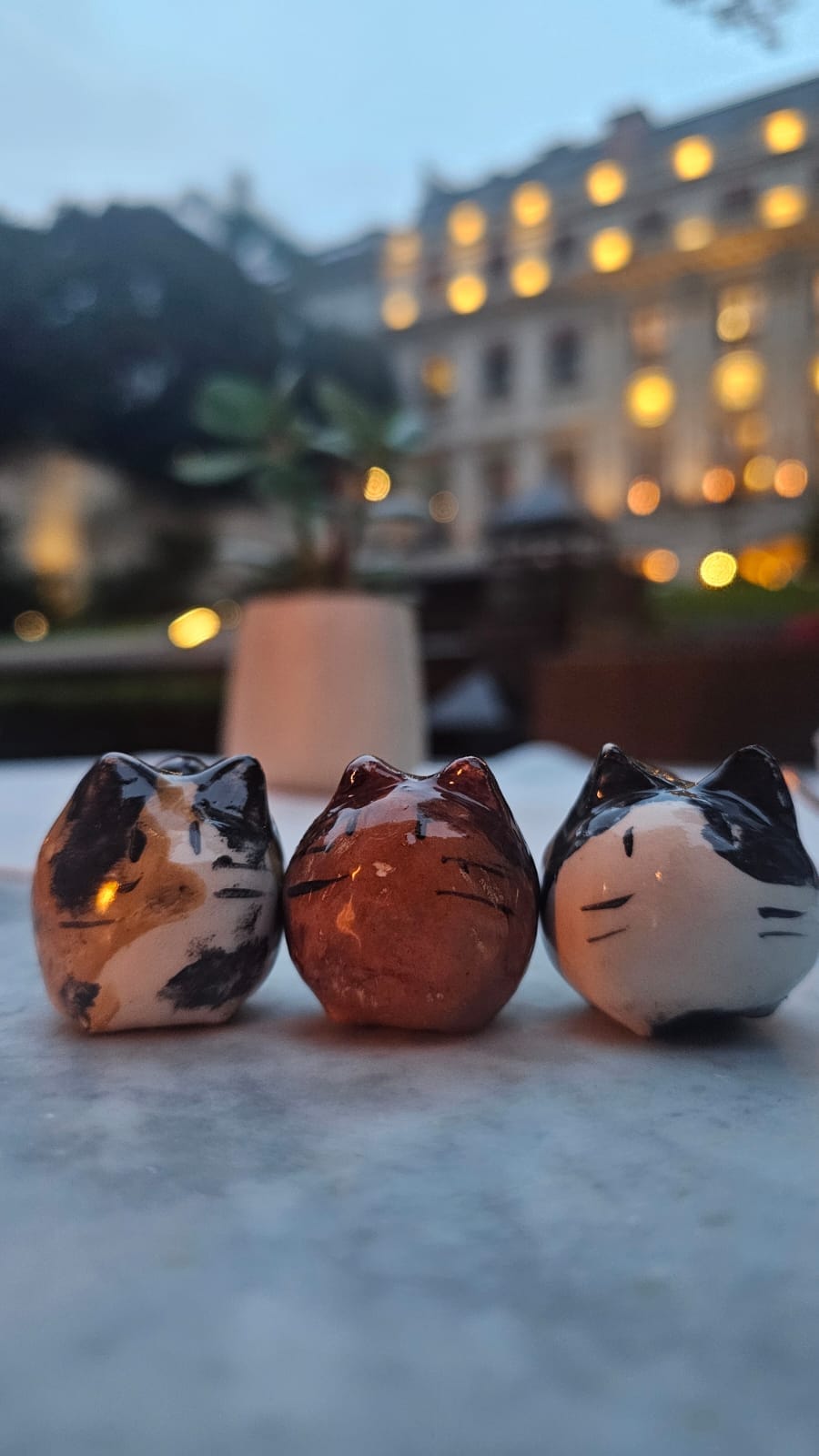 Las tres miniaturas de cerámica de los gatos de Flor en la mesa del jardín